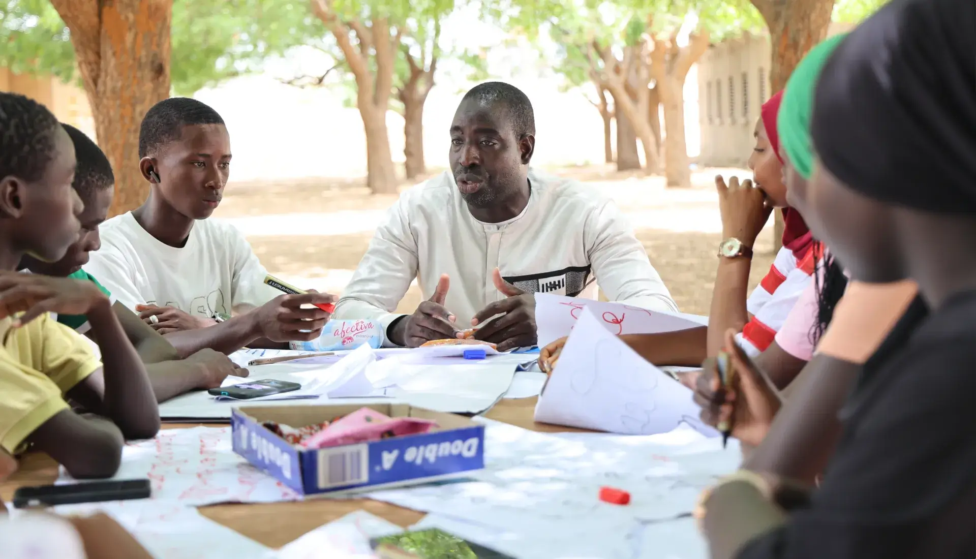 Souleymane, professeur d’histoire et de géographie discutant avec un groupe de jeunes filles sur la gestion des menstrues à l’école